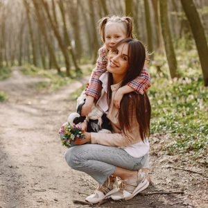 Beautiful family in a park. Woman in a white shirt and jacket. Mother with daughter.