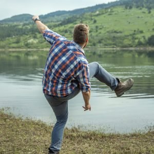 A young man skipping a stone on lake water