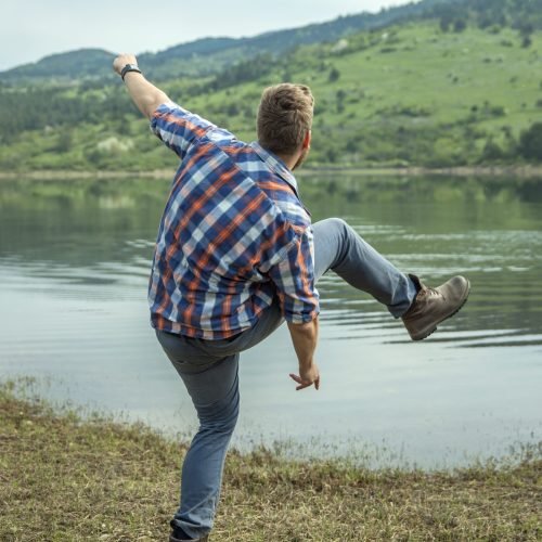 A young man skipping a stone on lake water